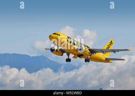 Spirit Airlines Airbus A319 fliegen Sie vom internationalen Flughafen von Los Angeles, LAX, Wolken über die schneebedeckten San Gabriel Berge dahinter. Stockfoto