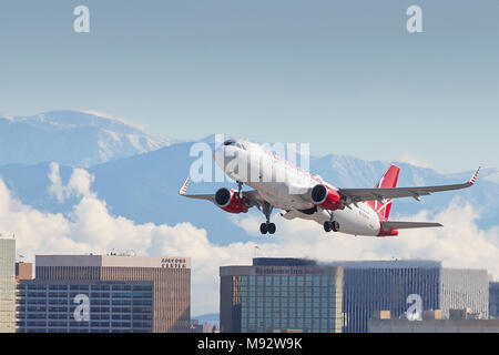 Virgin America Airbus A320 Flugzeug, vom internationalen Flughafen Los Angeles, LAX, die schneebedeckten San Gabriel Berge dahinter. Stockfoto