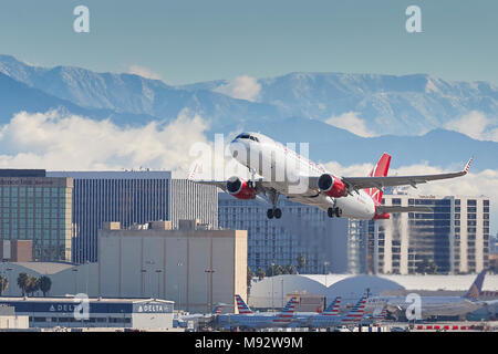 Virgin America Airbus A320 Flugzeug, vom internationalen Flughafen Los Angeles, LAX, die schneebedeckten San Gabriel Berge dahinter. USA. Stockfoto