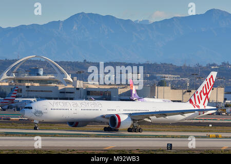 Jungfrau Australien Airlines Boeing 777-300Passenger Jet Ankunft in Los Angeles International Airport LAX. Die San Gabriel Berge dahinter. Stockfoto