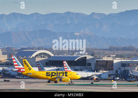 Spirit Airlines Airbus A319 rollt in Richtung Terminal nach der Landung am Los Angeles International Airport LAX. Das Hollywood Zeichen im Hintergrund. Stockfoto