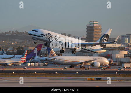 Alaska Airlines Boeing 737-800 vom Internationalen Flughafen Los Angeles, LAX, kurz nach Sonnenaufgang. Der alte Tower im Hintergrund. Stockfoto