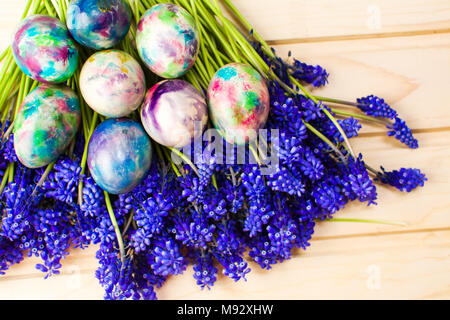 Handbemalte Ostereier und lila Blumen Stockfoto