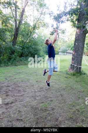 Teenager springt hoch in die Luft Birdie in einem Spiel der Rasen Badminton zurückzukehren. Clitherall Minnesota MN USA Stockfoto