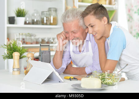 Portrait von älteren Mann mit Enkel Vorbereitung Abendessen in der Küche Stockfoto