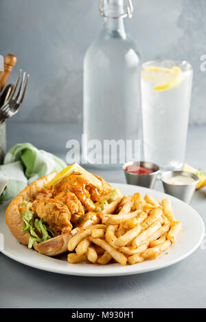 Po boy Sandwich mit gebratenen Garnelen und Pommes Frites Stockfoto