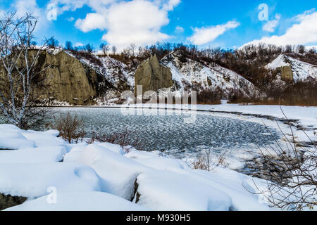 Lake Ontario im Winter zeigt grün Eiswasser und felsiges Gelände mit Felsen in weißer Schnee über einen sonnigen Tag abgedeckt Stockfoto