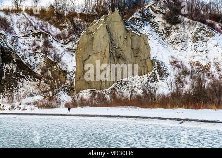 Lake Ontario im Winter zeigt grün Eiswasser und felsiges Gelände mit Felsen in weißer Schnee über einen sonnigen Tag abgedeckt Stockfoto