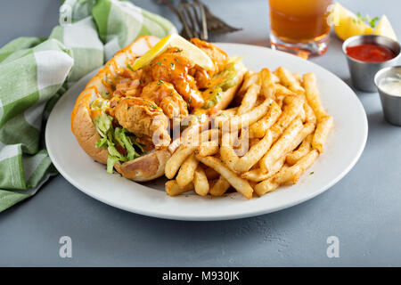 Po boy Sandwich mit gebratenen Garnelen und Pommes Frites Stockfoto