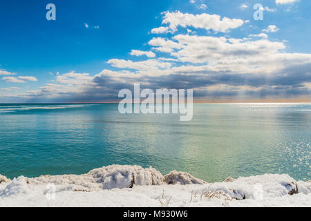 Winterlandschaft Szene mit weißen Schnee und eisigen Wasser See Küste, an einem schönen sonnigen Tag mit hohem Kontrast Himmel Stockfoto