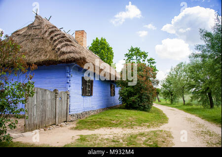 Mazovian Dorf in Sierpc - Village Stil Rekonstruktion oder Skansen, in der polnischen Landschaft. Hell blau Cottage mit traditionellen thatc lackiert Stockfoto