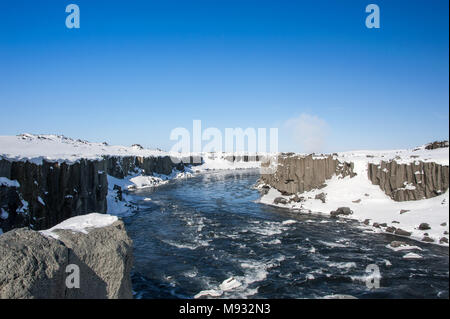 Winterlandschaft, schnell fließenden Fluss, klaren, blauen Himmel und vulkanische Schlucht in der Nähe von Selfoss Wasserfall an der Jokulsa eine Fjollum Fluss Stockfoto