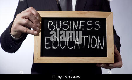 Business Bildung auf die Tafel geschrieben, Geschäftsmann Schild hält, Zukunft Stockfoto