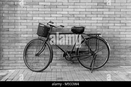 Eine traditionelle Fahrrad ist auf seinem Stand vor einer Wand geparkt in Peking, China Stockfoto