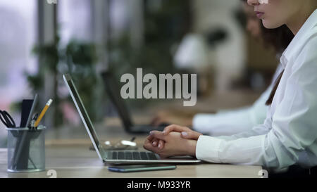 Ernsthafte weibliche Mitarbeiter sitzen und die Hände gefaltet, langweiliger Job müde Stockfoto