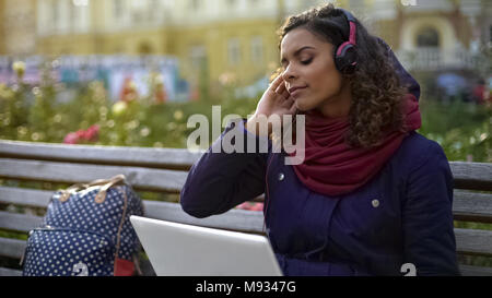 Hübsches Mädchen in Kopfhörer genießen Sie Atmosphäre der Lieblingsband Konzert im Freien Stockfoto