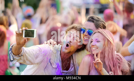 Freunde lächelnd und für selfie auf dem Smartphone, Farbe festival Posing, Spaß Stockfoto