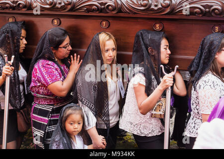 Frauen leiden mit einem Schwimmer in der Prozession von San Bartolome de Becerra, Antigua, Guatemala Stockfoto