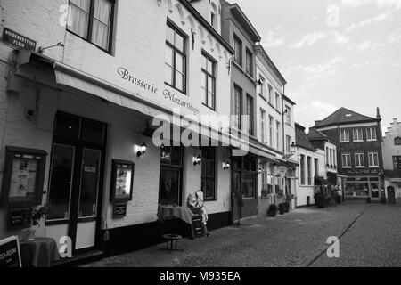 Huidenvettersplein, Brügge, Belgien: Die Brasserie 't Mozarthuys und andere Restaurants auf dem zauberhaften kleinen Platz. Schwarz-weiße Version Stockfoto