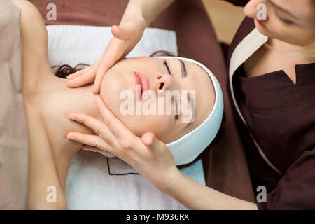Schöne Frau an eine Gesichtsmassage in einem Spa Salon Stockfoto