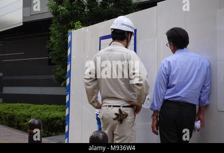Bauarbeiter und Manager diskutieren vor der Baustelle Stockfoto