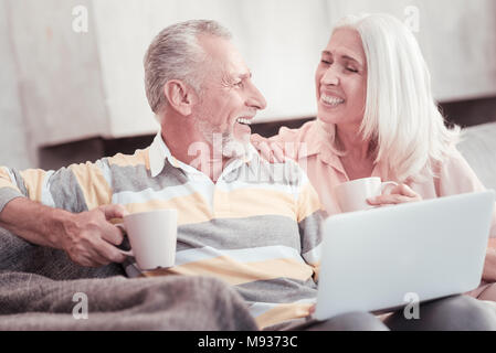 Glücklich im Alter von Paar lachen und trinken Tee. Stockfoto
