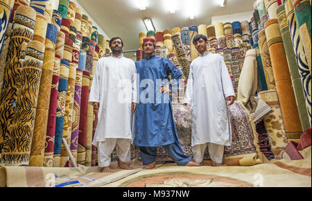 Eine Gruppe von nicht identifizierten männlichen Pakistanischen Verkäufer am Teppich Souk in Abu Dhabi, der Hauptstadt der Vereinigten Arabischen Emirate. Stockfoto