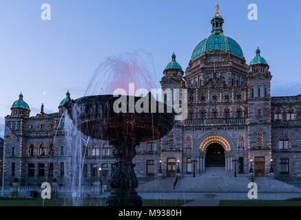 Der Brunnen vor dem Gebäude des Parlaments in Victoria, British Columbia, Kanada, gesehen in der Dämmerung mit den Brunnen und Gebäude beleuchtet. Stockfoto