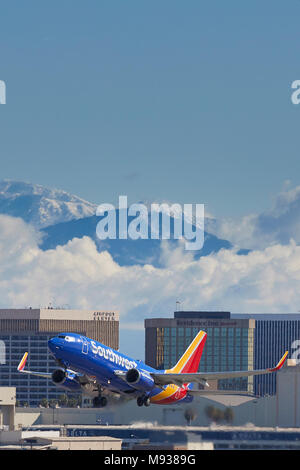 Southwest Airlines Boeing 737 Airliner Nehmen hinter Weg vom internationalen Flughafen von Los Angeles, LAX, Cloud und Schneebedeckten San Gabriel Mountains Stockfoto