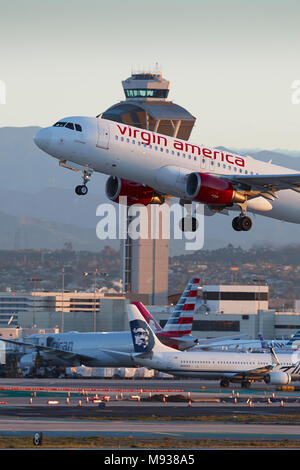 Virgin America Airbus A320 Jet Airliner, vom LAX, Los Angeles International Airport, der ATC-Turm im Hintergrund. Stockfoto