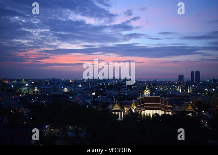 Ansicht der Loha Prasart Tempel vom goldenen Berg Tempel in Bangkok mit einem bunten Himmel und erhellen die Sehenswürdigkeiten der Stadt bei Sonnenuntergang. Stockfoto