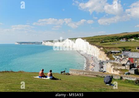 Paar sitzt auf einer Klippe an einem Sommertag, an Birling Gap, South Downs National Park East Sussex England Großbritannien Stockfoto