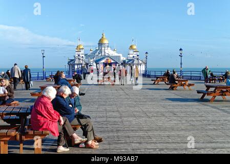 Ältere Menschen die Frühlingssonne auf der Pier von Eastbourne, East Sussex England Großbritannien Stockfoto