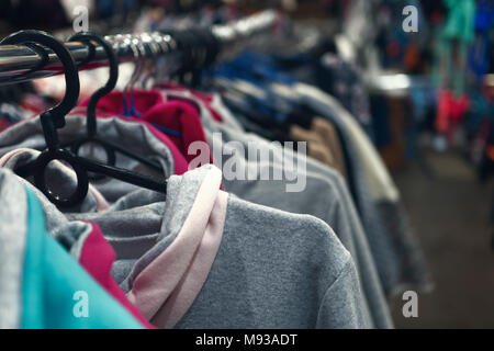 Kleidung hängt auf einem Kleiderbügel in einem Geschäft Stockfoto