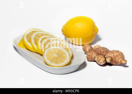 Studio Fotografie von Zitronenscheiben und Zitrone Frucht mit Ginger Root auf einem weißen Hintergrund. Gesunde Zutaten für Erkältung heilen Medizin Stockfoto