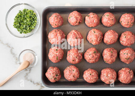 Rohes Fleisch Kugeln vorbereitet und bereit gebacken auf ein Blatt zu sein pan mit Gewürzen auf der Seite Stockfoto