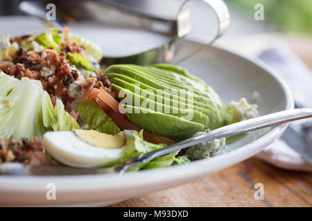 Abendessen Cobb Salat mit Römersalat, Tomaten, Eier, Avocado und Speck mit Ranch Dressing auf der Seite Stockfoto