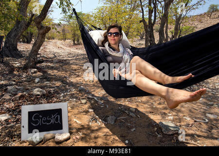Frau Entspannen in der Hängematte - Huab unter Leinwand, Damaraland, Namibia, Afrika Stockfoto