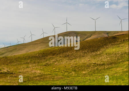 Windenergieanlagen stand groß und stark gegen die Wüste Landschaft aus sanften Hügeln in der Columbia River Gorge Stockfoto