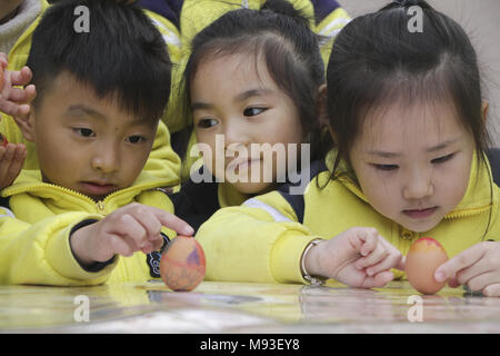 Hangzh, China. 21 Mär, 2018. Kinder lernen Frühjahr Eier in einem Kindergarten in Hangzhou zu stehen, im Osten China Zhejiang Provinz, Kennzeichnung, die Frühlings-tagundnachtgleiche. Es ist eine Tradition zu den Eiern auf den Frühlingspunkt in China stehen. Credit: SIPA Asien/Pacific Press/Alamy leben Nachrichten Stockfoto