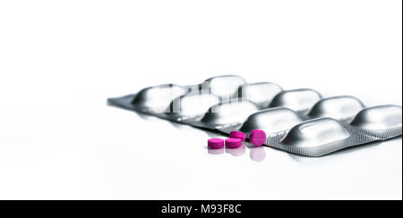 Kleine rosa Pillen und Tabletten Aluminium-durchdrückpackungen Packung Pillen auf weißem Hintergrund mit Kopie Raum isoliert. Stockfoto