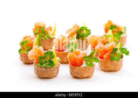 Croustades knuspriges Gebäck Fällen gefüllt mit gesalzenen Lachs und Avocado isoliert auf weißem Stockfoto