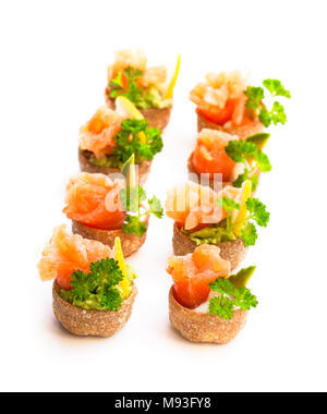 Croustades knuspriges Gebäck Fällen gefüllt mit gesalzenen Lachs und Avocado isoliert auf weißem Stockfoto