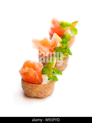 Croustades knuspriges Gebäck Fällen gefüllt mit gesalzenen Lachs und Avocado isoliert auf weißem Stockfoto