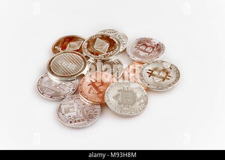 Physische cryptocurrency, Bitcoin, des Astraleums, Litecoin, Bindestrich und eine zufällige Ansammlung von Münzen auf weißem Hintergrund Stockfoto