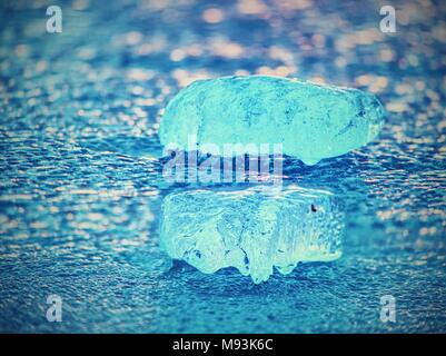 Shining Eisberge und Eisschollen, Eis Schlupfwinkeln reflektierten Strahlen in die glatte Wasseroberfläche. Treibeis in der Lagune. Stockfoto