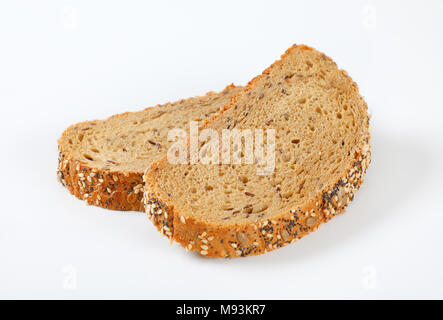 Zwei Scheiben Brot mit Mohn, Sonnenblumenkerne und Sesam auf weißem Hintergrund Stockfoto