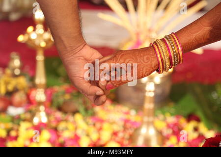 Indische Hochzeit Ritual und Zeremoniell mit hinduistischen Braut und Bräutigam. Ehe Hintergrund mit ein paar halten sich an den Händen. Stockfoto