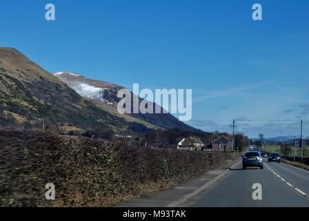 Reisen b Straße durch Clackmannanshire hinter den schneebedeckten Ochil Hills. Stockfoto
