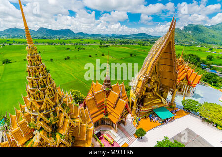 Ein Blick von Oben auf die Pagode, goldene Buddha Statue mit Reisfeldern und Berg, Tiger Cave Tempel (Wat Tham Seua) thailändische und chinesische Tempel in K Stockfoto
